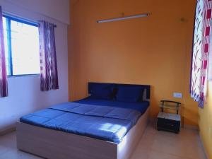 馬哈巴萊斯赫瓦爾的住宿－Echo Villa，一间卧室配有一张带蓝色床单的床和一扇窗户。