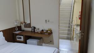a bedroom with a bed and a desk and a staircase at Baan Wanchart in Bangkok