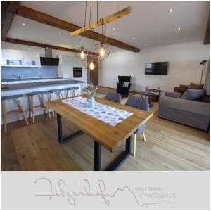comedor y sala de estar con mesa de madera en Panorama Appartements Filzerhof, en Kirchberg in Tirol