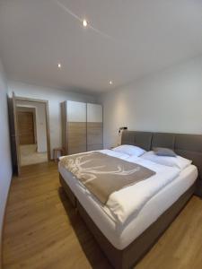1 dormitorio con 1 cama grande con sábanas blancas en Panorama Appartements Filzerhof, en Kirchberg in Tirol