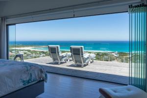 a bedroom with a view of the ocean from a balcony at Namaste Cape Point in Cape Town