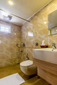 a bathroom with a toilet and a sink at Hotel Arches in Cochin