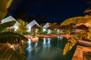 a resort with a swimming pool at night at Heart of Zanzibar Bungalows in Paje