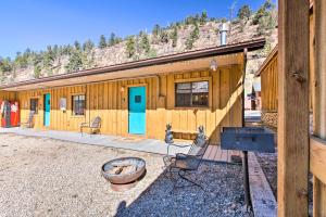 a wooden cabin with two chairs and a grill at Red River Retreat Walk to Lifts, Mtn Views! in Red River