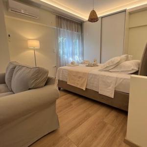 um quarto com uma cama, um sofá e uma janela em Luxury Studio “Atene” em Atenas