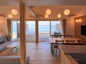 Sanuki的住宿－Beach SPA TSUDA 0 Cero棟，客厅配有桌子,享有海景