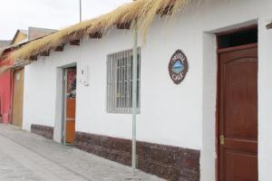 a white building with a thatch roof at Hostal Cali in Putre