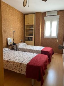 1 dormitorio con 2 camas y ventana en Piso Turístico Huétor Vega (Granada) en Huétor Vega