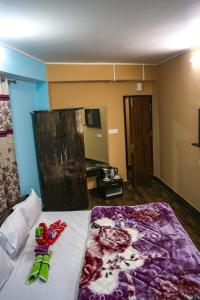 a bedroom with a bed with a purple blanket on it at SHARTHI HOMESTAY AND LODGING in Namchi