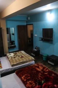 a room with two beds and a flat screen tv at SHARTHI HOMESTAY AND LODGING in Namchi