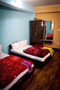 a bedroom with two beds and a mirror in it at SHARTHI HOMESTAY AND LODGING in Namchi