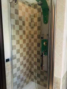 prysznic ze szklanymi drzwiami i ścianą wyłożoną kafelkami w obiekcie Roma House Alessandrino w Rzymie