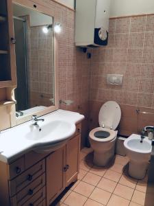 W łazience znajduje się umywalka, toaleta i lustro. w obiekcie Roma House Alessandrino w Rzymie