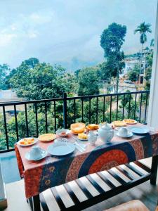 a table with plates of food on top of a balcony at Poomaz Peace Palace in Ella