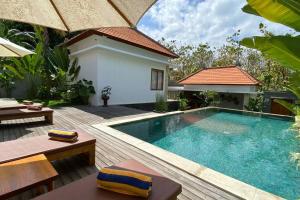 un patio trasero con piscina y una villa en Nau Nusa Villa, en Nusa Penida