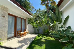 a garden with a bench and some plants at Nau Nusa Villa in Nusa Penida