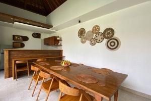 a dining room with a wooden table and chairs at Nau Nusa Villa in Nusa Penida