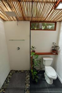 a bathroom with a toilet and a window at LaFinca Hostel Siargao in San Isidro