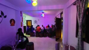 a group of people sitting in a room with purple lighting at KAILASH VIEW SARAHAN in Sarāhan