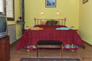 a bedroom with a bed with a red comforter at Bellevue Budapest B&B in Budapest