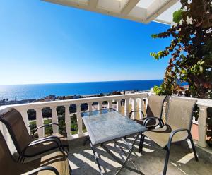 d'une table et de chaises sur un balcon donnant sur l'océan. dans l'établissement Clear Sunset, à Kanali