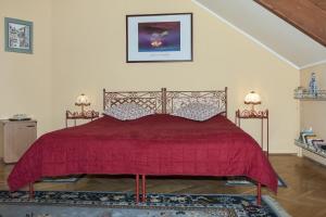 1 dormitorio con 1 cama con colcha roja en Bellevue Budapest B&B, en Budapest