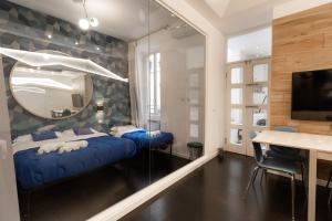 sypialnia z niebieskim łóżkiem i lustrem w obiekcie Trastevere four seasons Manara w Rzymie