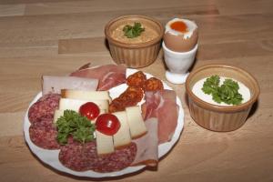 a plate of food with meats and cheese and dips at Bellevue Budapest B&B in Budapest