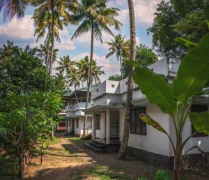 a row of palm trees in front of a building at Secret Paradise in Varkala