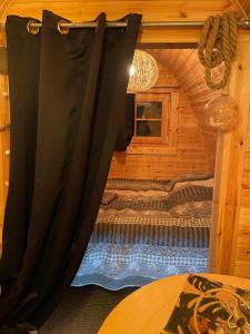 een slaapkamer met een bed in een blokhut bij Le charmant Pod du Parolais in Beauvoisin