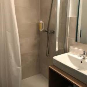 bagno con doccia, lavandino e doccia di Ashley Hotel Le Mans Sud a Ruaudin