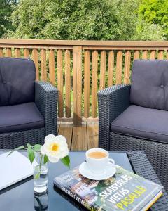 a table with a cup of coffee and a book at Oāze Ģimenei in Pāvilosta