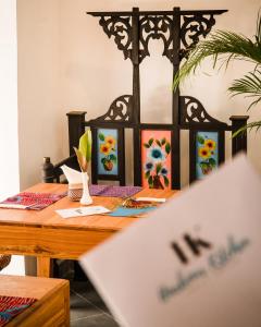 a wooden table with some paintings on it at Emerald Palm in Zanzibar City