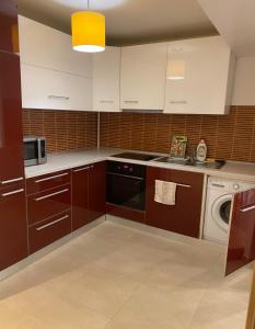 a kitchen with white cabinets and a dishwasher at DMT Apartament regim hotelier Rin in Bucharest
