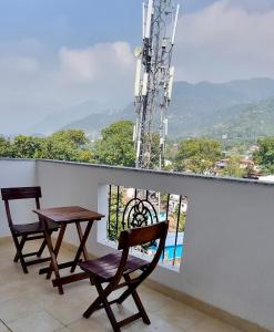 two chairs and a table on a balcony with a view at Hill Nest with a serene view in Dehradun