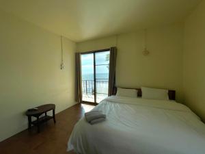 a bedroom with a bed and a large window at Mimo Guesthouse in Ko Chang