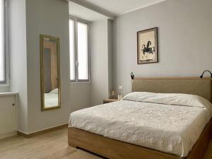 ein Schlafzimmer mit einem großen Bett und einem Spiegel in der Unterkunft Appartamento centralissimo in Piazza Bresca in Sanremo