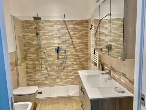 ein Bad mit einer Dusche, einem WC und einem Waschbecken in der Unterkunft Appartamento centralissimo in Piazza Bresca in Sanremo
