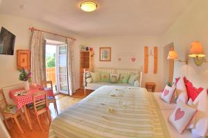 a bedroom with a large bed and a living room at Hannas ALPENGRUSS Apartment & Zimmer in Seefeld in Tirol