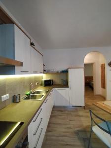 レーヴィコ・テルメにあるAppartamento Nido in centroの白いキャビネットとシンク付きのキッチン