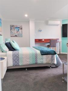 a bedroom with a bed and a desk in it at Palm Beach Guest House in Rockingham