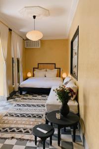um quarto de hotel com uma cama e uma mesa em Riad Maison 24 em Marrakech