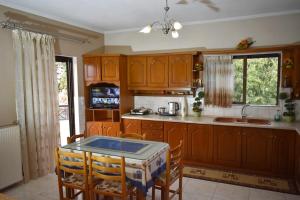 una cocina con armarios de madera y una mesa con sillas. en Stefanos Apartment en Tríkala