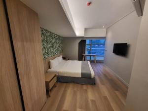 a bedroom with a bed and a television in it at Infinity Tower Suites in Manila