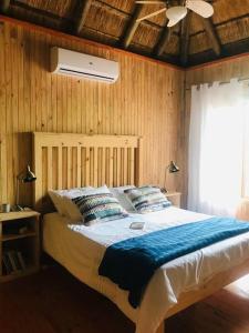 a bedroom with a large bed with a ceiling fan at Habibi Holiday Home in Marloth Park