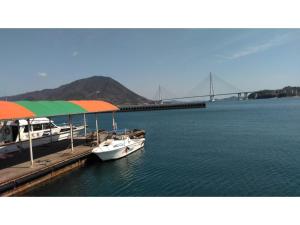 deux bateaux sont amarrés à un quai avec un pont dans l'établissement Guesthouse Farmor - Vacation STAY 15083v, à Imabari