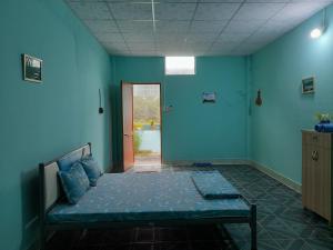 a bedroom with a bed in a room with blue walls at Cu Chi Boutique Farmstay in Ho Chi Minh City