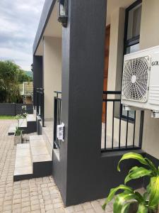 a white air conditioner on the side of a building at Spring Acres Guesthouse in Nelspruit