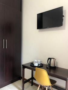 a room with a table and a yellow chair at Spring Acres Guesthouse in Nelspruit