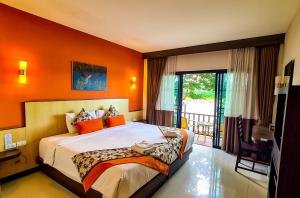 清孔Chiangkhong Teak Garden Riverfront Onsen Hotel- SHA Extra Plus的卧室里有一张床，墙壁是橙色的